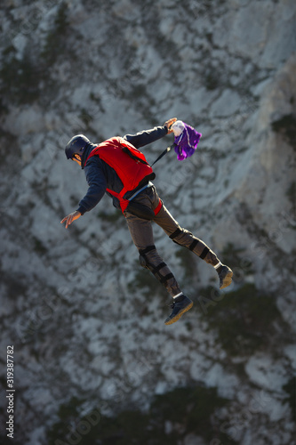 Figure of a base jumper in free fall closeup, after jumping from a cliff, at the time of the throw of the pilot chute.