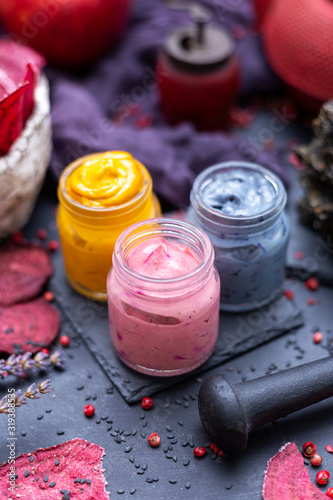 Colorful raw vegan cashew cream on a black table top with raw ingredients. Vegetarian diet food. Raw food. Cashew spread.