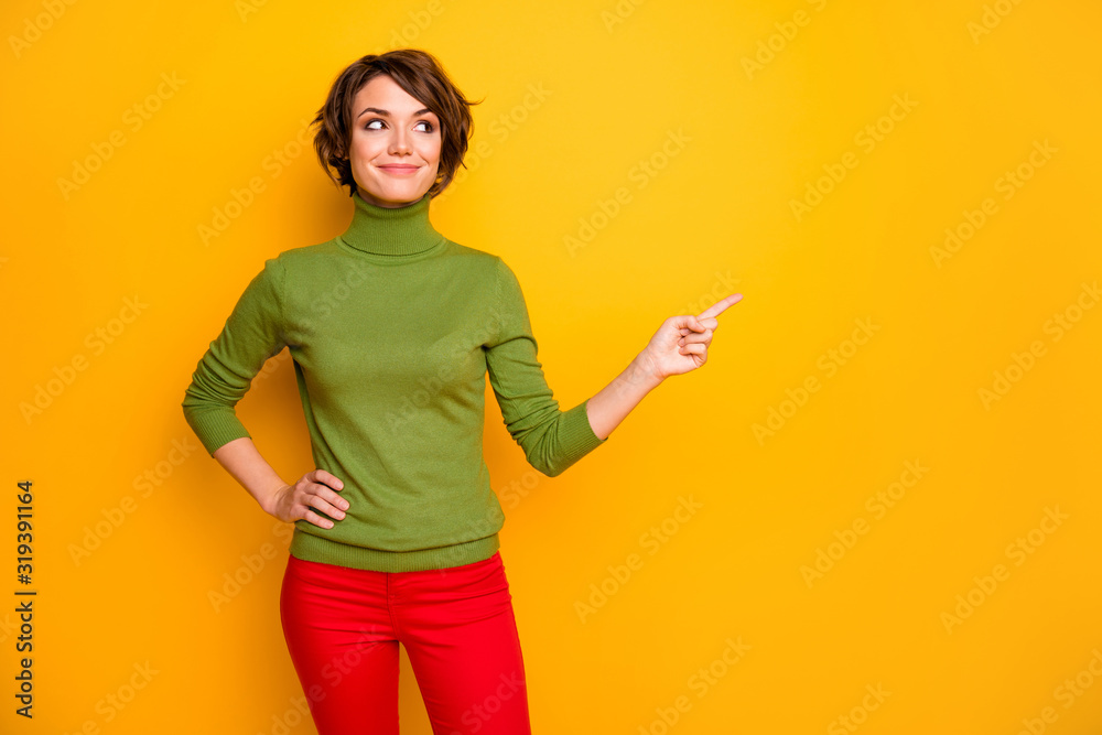 Photo of pretty lady indicating finger looking empty space advising black friday low prices wear casual green turtleneck red trousers isolated yellow color background Photo of pretty lady indicating finger looking empty space advising black friday low prices wear casual green turtleneck red trousers isolated yellow color background