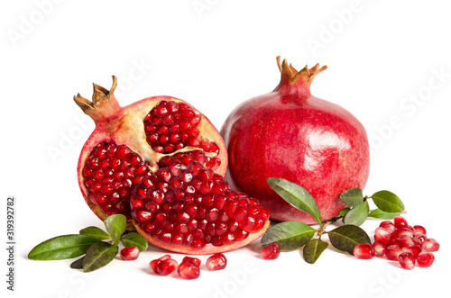 whole Pomegranate and two parts of Pomegranate with leaves and seeds isolated on white