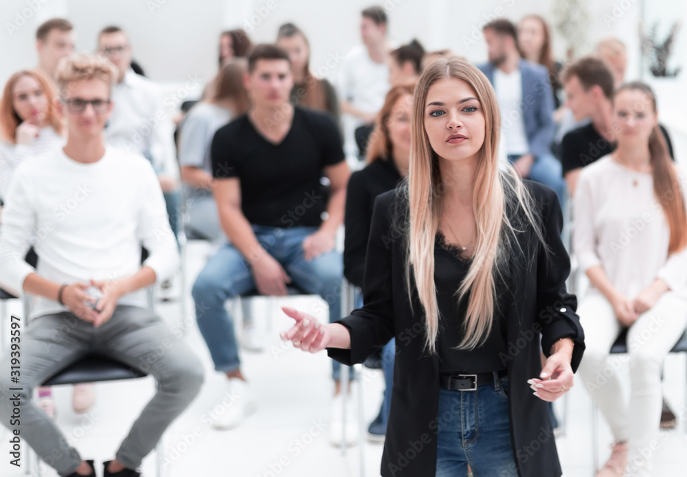 female speaker standing in front of the audience in the conference room. female speaker standing in front of the audience in the conference room.