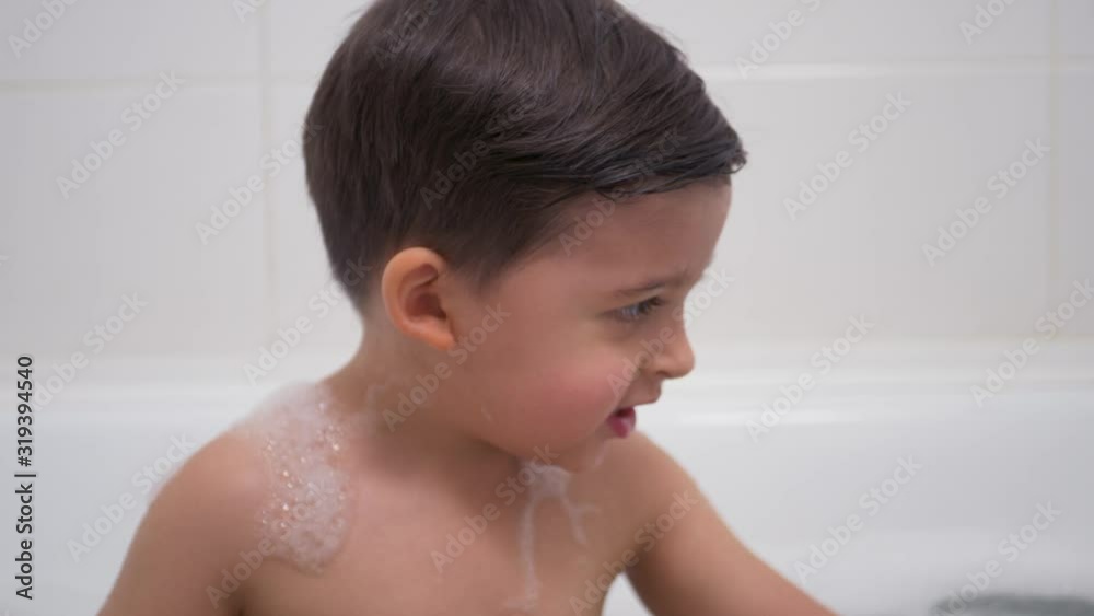 small boy with a black mustache sits in the bathroom small boy with a black mustache sits in the bathroom