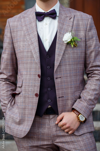 Groom in a beautiful plaid suit and bow-tie