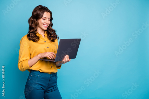 Portrait of her she nice attractive lovely cheerful cheery wavy-haired girl holding in hands laptop creating presentation isolated over bright vivid shine vibrant green blue turquoise color background