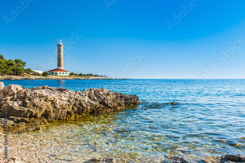 Croatia, Adriatic sea coastline, island of Dugi Otok, old lighthouse of Veli Rat on the stone shore, rocky shore in foreground