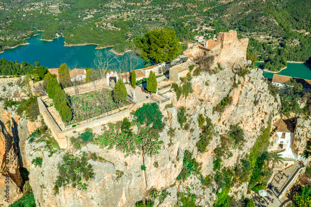 Panoramic view of popular Spanish vacation destination El Castell de Guadalest above a beautiful water reservoir with 2 castles and fortified enclave