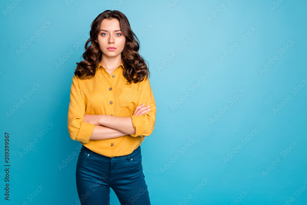 Photo of attractive curly business lady hold hands crossed seriously looking colleagues dislike coming work late wear yellow shirt trousers isolated blue color background