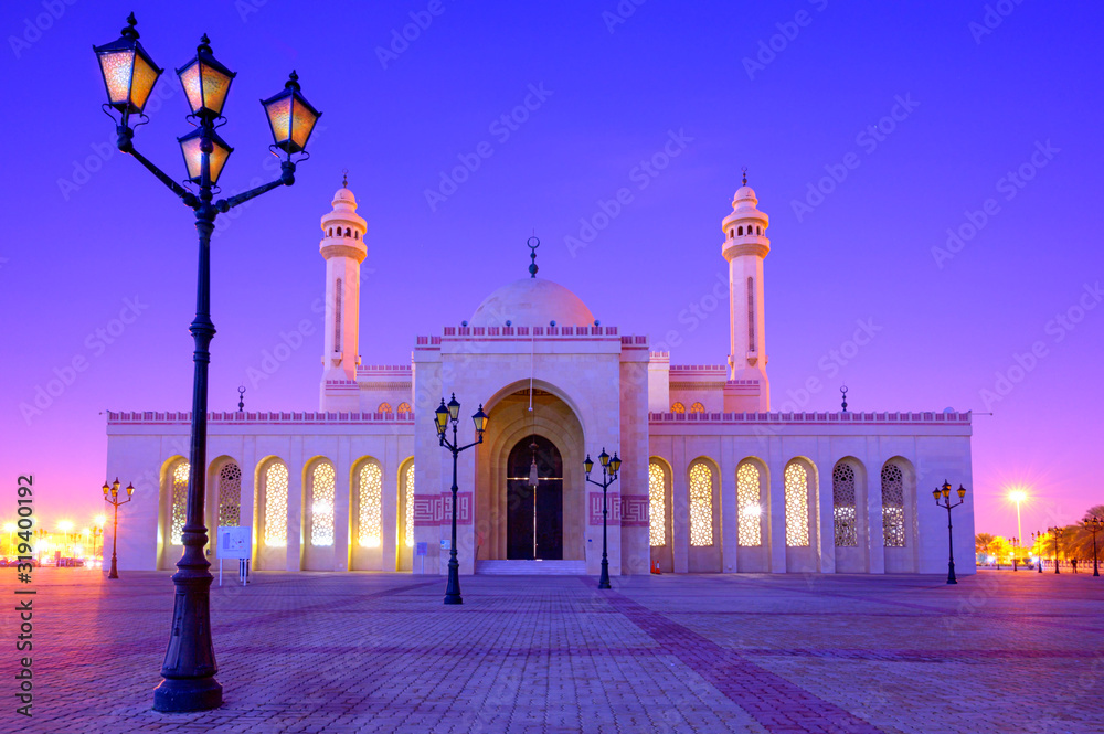 Beautiful architecture of Al Fatch Grand Mosque with lights on early morning over blue sky background, Manama Bahrain