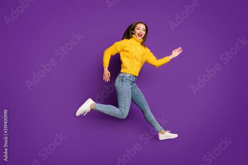 Full length body size profile side photo of cheerful positive cute pretty girlfriend running in jeans denim expressing positive emotions isolated vivid color background purple