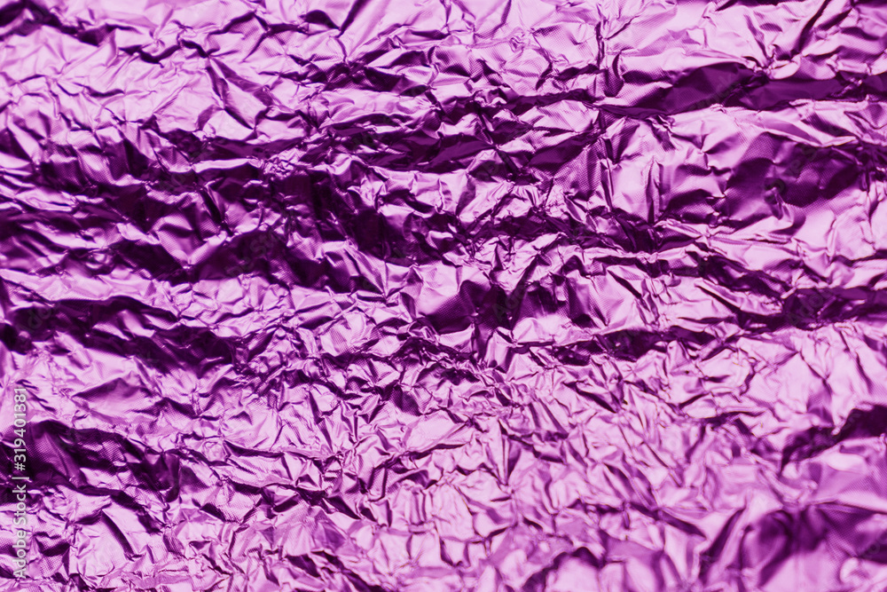 Fototapeta premium Purple crumpled sheet of aluminum foil. Foil background.