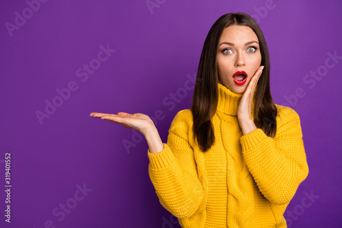 Photo of woman in stupor holding new solution to your problem offerring you new information isolated vivid color purple background