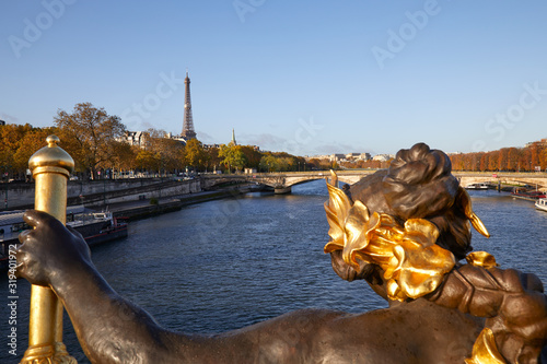 Eiffel tower and Seine river seen in a sunny autumn day from Alexander III bridge in Paris, statue detail © andersphoto