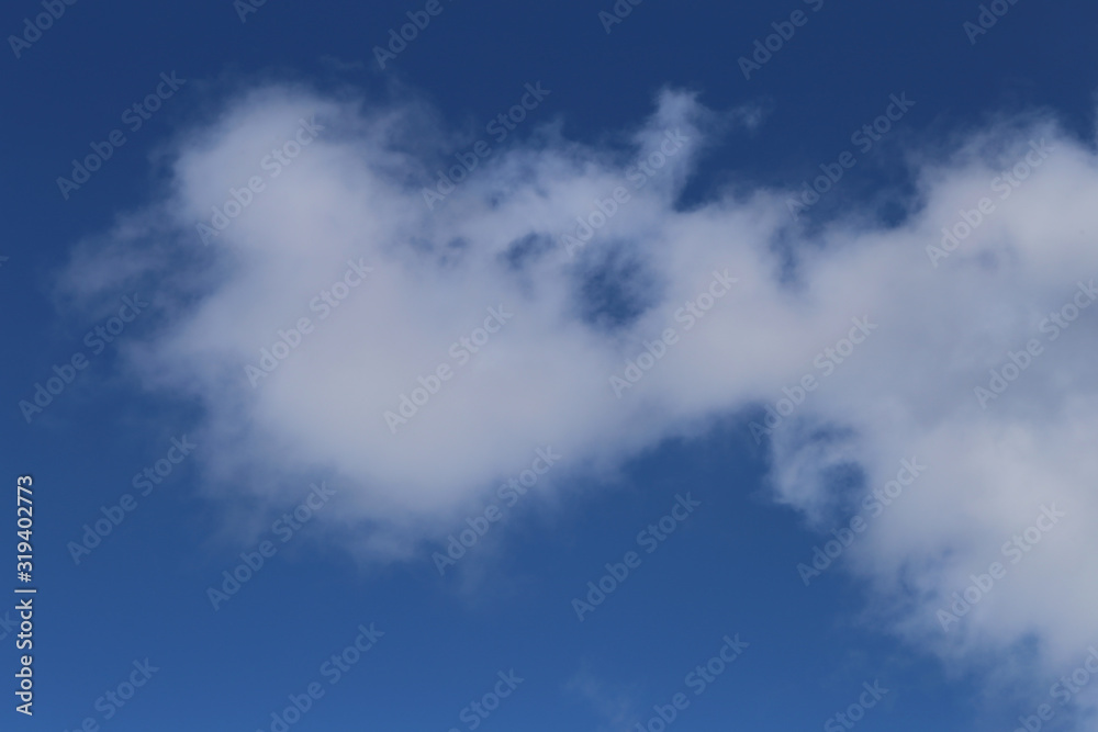 Blue sky with cute white clouds. Sunny summer day sky. Beautiful, relaxing background image that symbolizes happiness, religion and freedom. Color image. Blue sky with cute white clouds. Sunny summer day sky. Beautiful, relaxing background image that symbolizes happiness, religion and freedom. Color image.