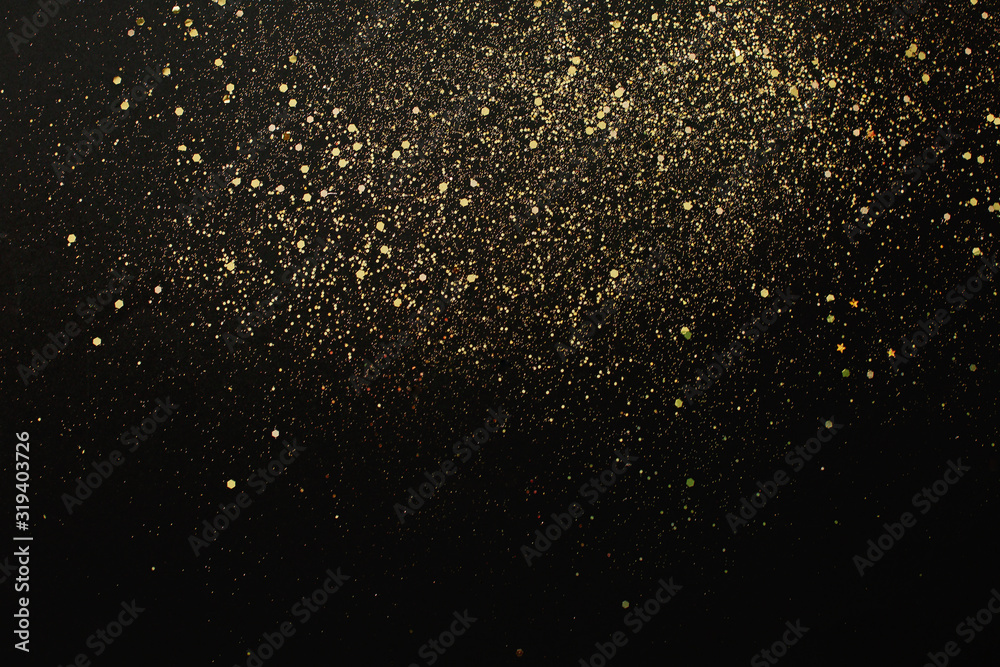 Gold glitter on black background. Holiday abstract texture