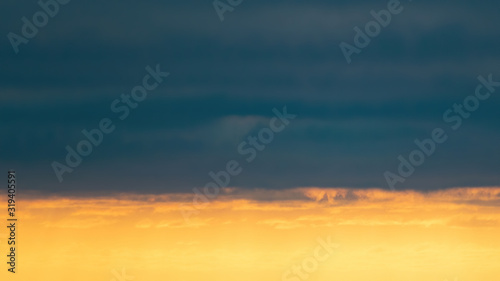 View of low edge of dark clouds with low sun light underneath © Emagnetic