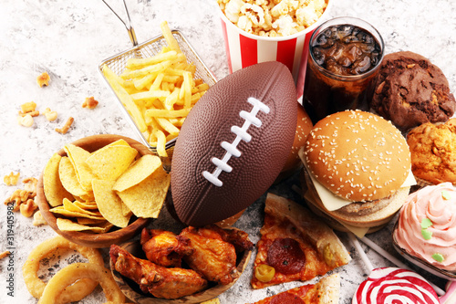 Foto chicken wings, fries and onion rings for football on a table
