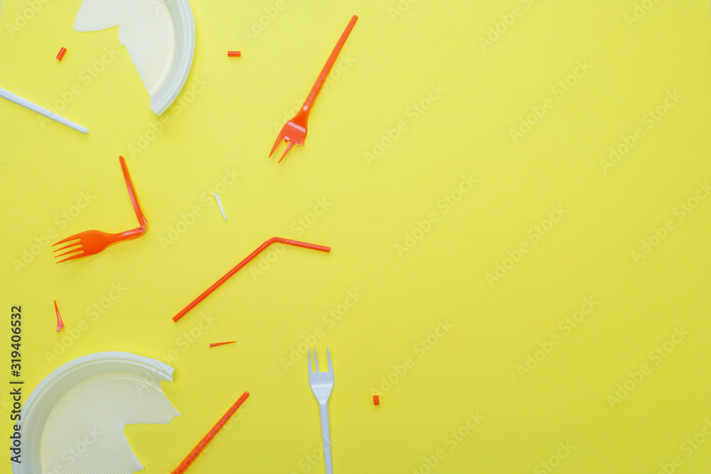Plastic garbage on a yellow background. Disposable forks, plates, tubes. Copy space. Plastic garbage on a yellow background. Disposable forks, plates, tubes. Copy space.