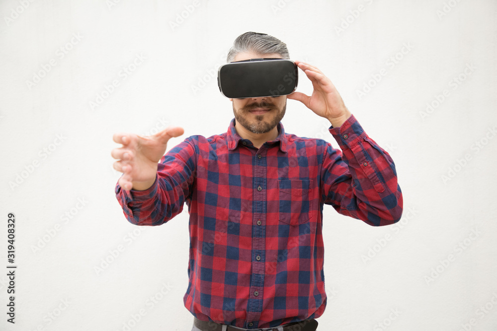 Studio shot of young man testing virtual reality headset. Young man experiencing VR glasses. Technology concept Studio shot of young man testing virtual reality headset. Young man experiencing VR glasses. Technology concept