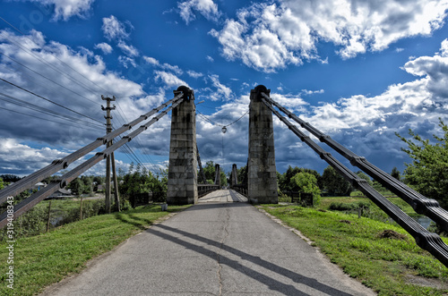 Stone pylons of the famous chain suspension bridge on the background of beautiful blue sky with clouds (Ostrov, Pskov oblast, Russia) photo