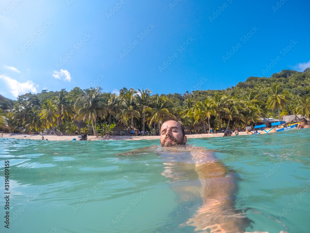 Punta Sal, Honduras »; December 4, 2019: A young man enjoying the water in Cocalito Beach