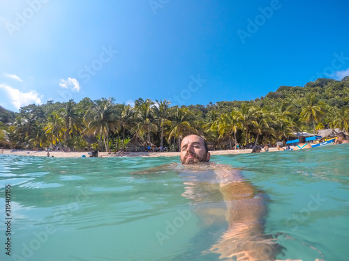 Punta Sal, Honduras »; December 4, 2019: A young man enjoying the water in Cocalito Beach