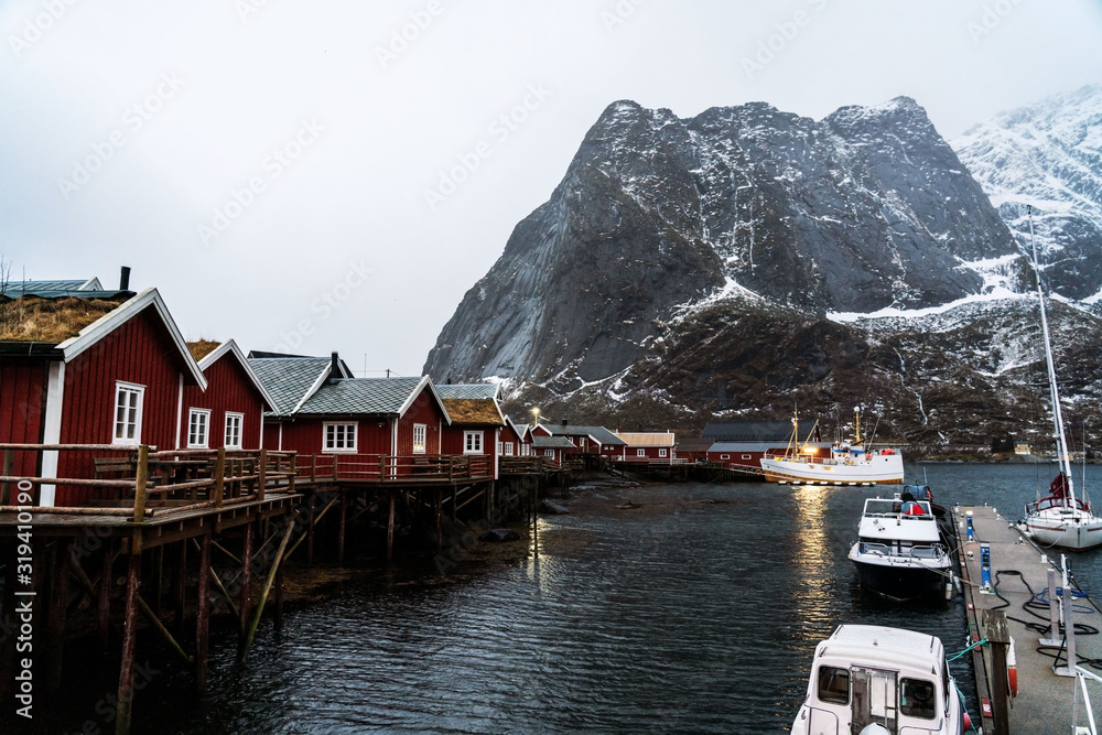 Still life photo of Reine village, Lofoten islands. Red fisherman's houses and boats in harbor.