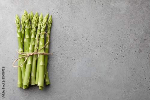 Bunch of green asparagus on concrete background photo