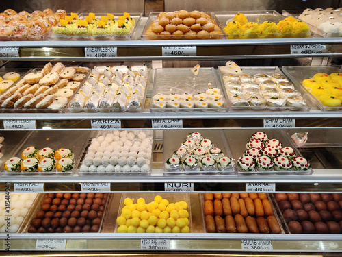 traditional Indian sweets kept in the fridge of a decorated mithai shop. Desserts like Laddoo, Barfi, and other dry fruits like cashew are gifted in festivals and weddings are on display photo
