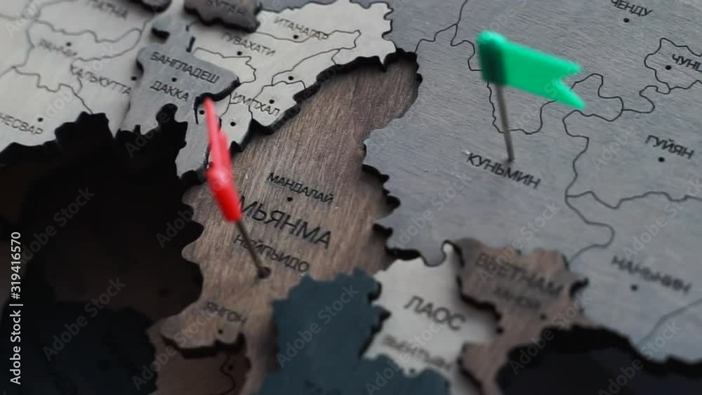 hand pin a flag to Myanmar country. wooden world map in Russian. Myanmar cities with colorful pins on a wooden map. The concept of travel, holiday in Asia. Pushpin on Naypyidaw.