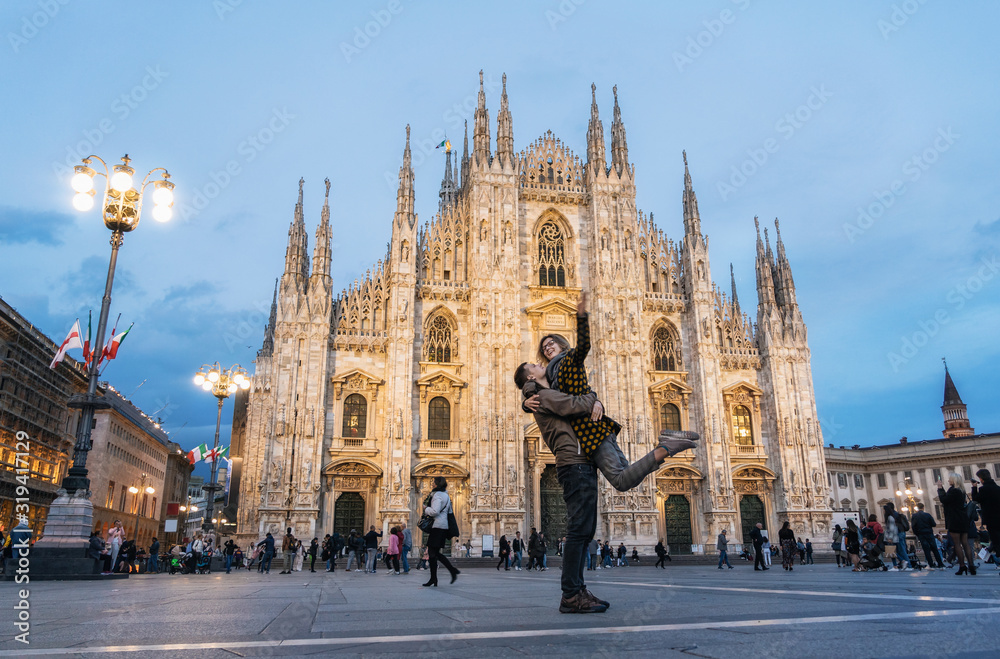 Naklejka premium Romantic young couple embracing in front of the Duomo, Milan, Italy