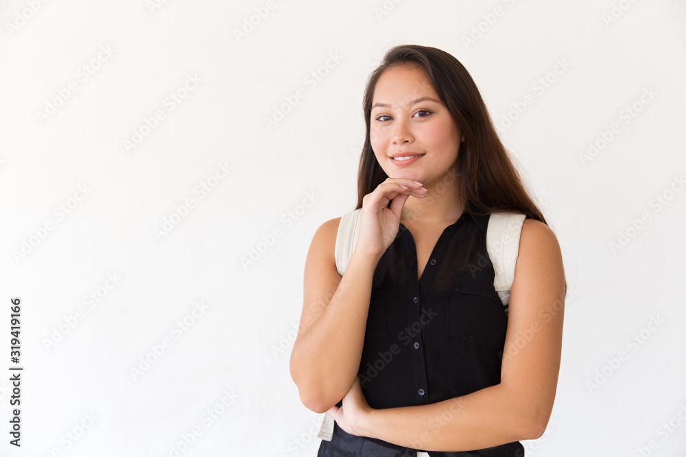 Happy young woman with backpack looking at camera. Portrait of beautiful young female college student standing with hand on chin and looking at camera. Education concept Happy young woman with backpack looking at camera. Portrait of beautiful young female college student standing with hand on chin and looking at camera. Education concept