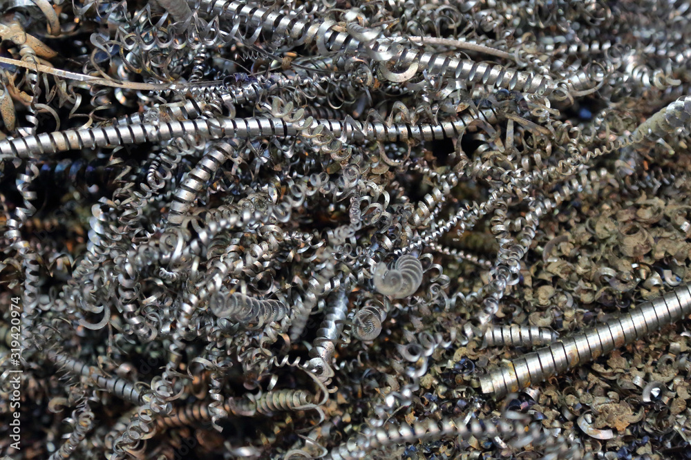 Textured surface of spiral-shaped iron chips after turning a blank on a lathe Textured surface of spiral-shaped iron chips after turning a blank on a lathe