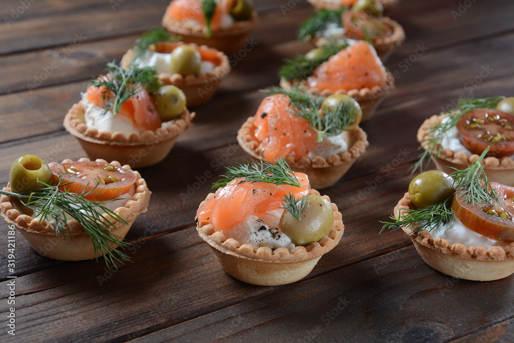 Tartalets with fresh salmon, philadelphia cream cheese, olives on wooden background Tartalets with fresh salmon, philadelphia cream cheese, olives on wooden background
