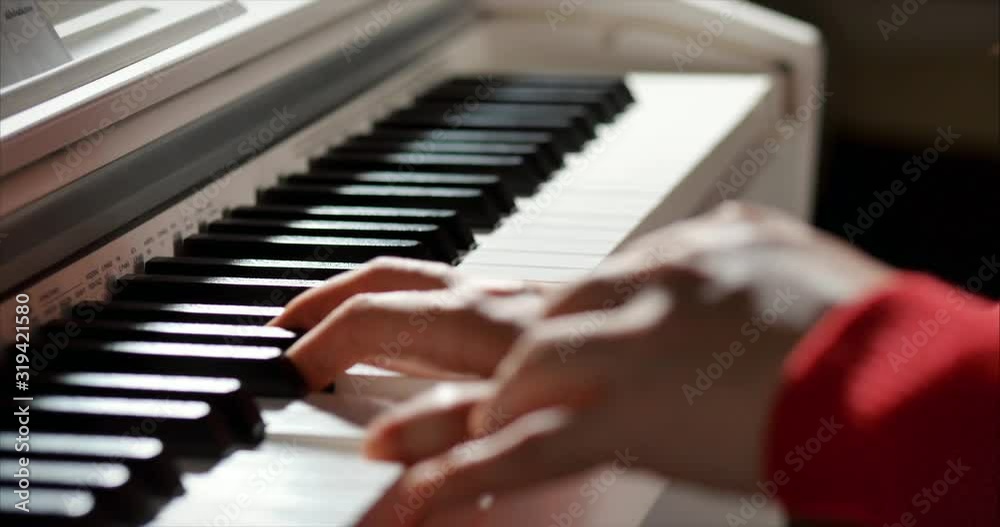 Woman or girl A student or professional pianist plays classical music on a beautiful white piano, hands of a pianist closeup in slow motion. Piano keys close up in dark colors. 4K