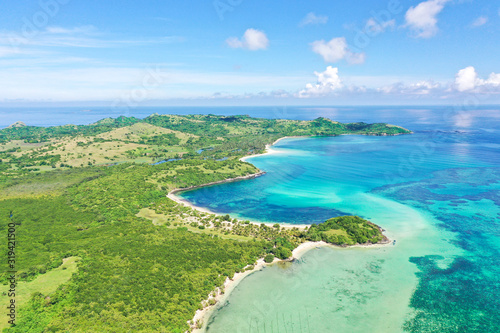 A tropical island with a turquoise lagoon and a sandbank. Caramoan Islands, Philippines.