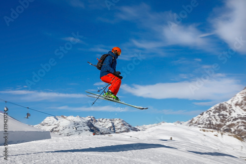 Male skier jumps in snow park against the blue sky © Alexey Kuznetsov