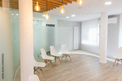 white waiting room lit with empty chairs