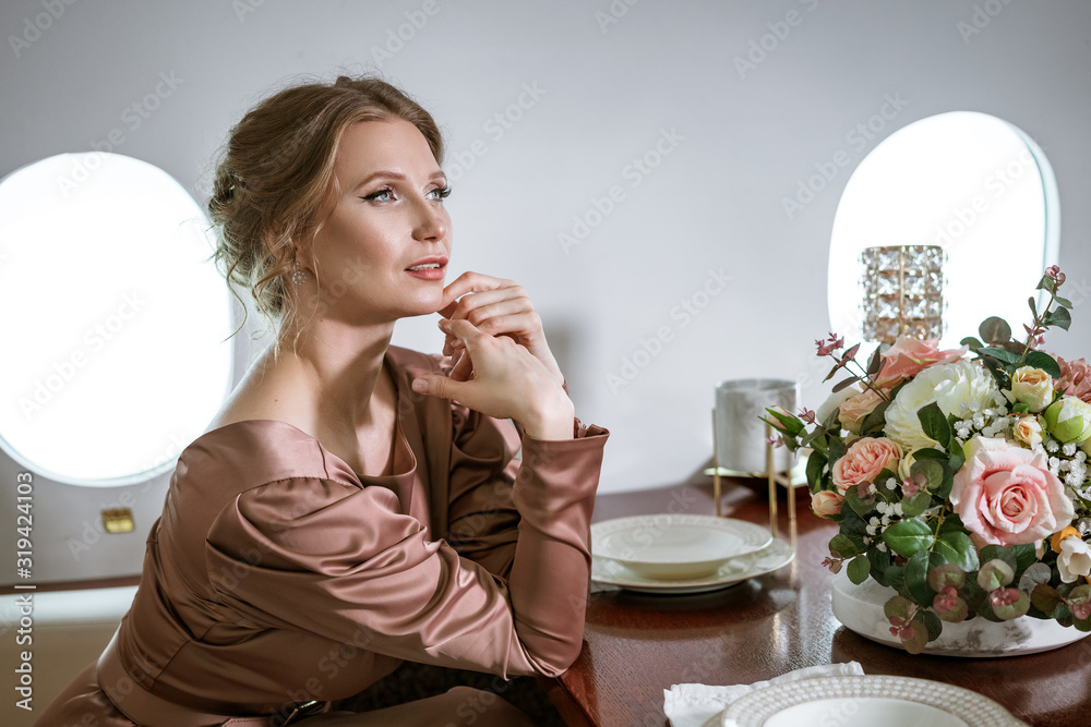happy stylish woman sitting in a private plane to the window happy stylish woman sitting in a private plane to the window