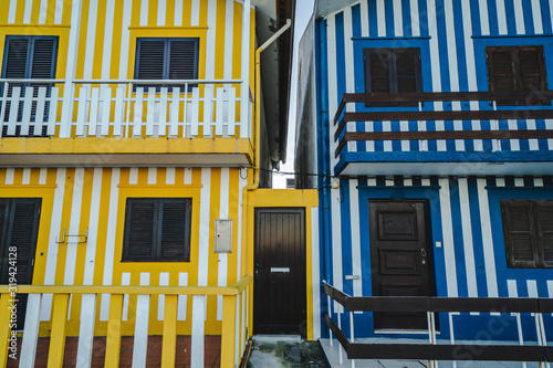 Colorful striped fishermen beach houses (Palheiros) with yellow, blue and white stripes in Costa Nova Portugal, a resort town near Aveiro
