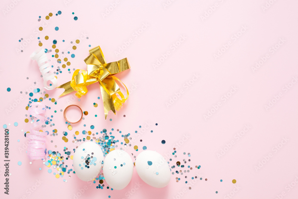 White eggs on a pink background, decorated with a gold bow, festive sparkles, with copy space. Easter concept. White eggs on a pink background, decorated with a gold bow, festive sparkles, with copy space. Easter concept.