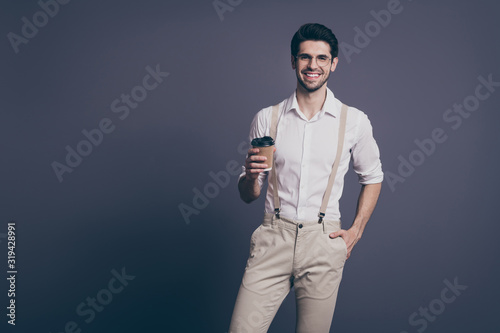 Photo of attractive successful business man leader drinking hot takeout coffee little break dressed formalwear shirt beige suspenders trousers specs isolated grey color background