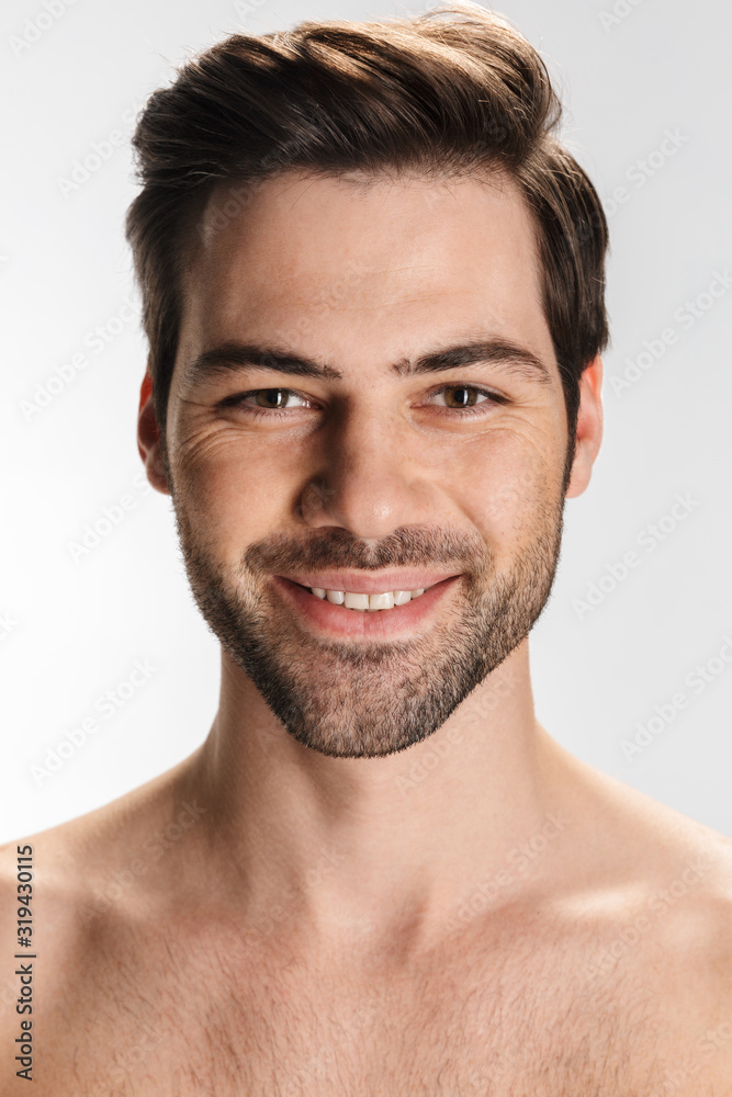 Photo of pleased half-naked man smiling and looking at camera Photo of pleased half-naked man smiling and looking at camera