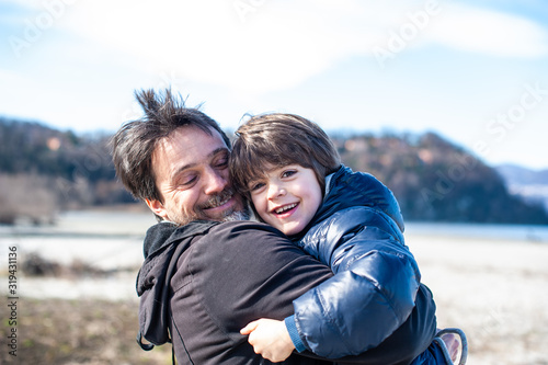 father and son hugging each other smiling outdoors