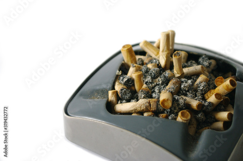 Ashtray full of cigarette butts, isolated on white background, stop smoking, bad habit. Warning picture on cigarette pack.