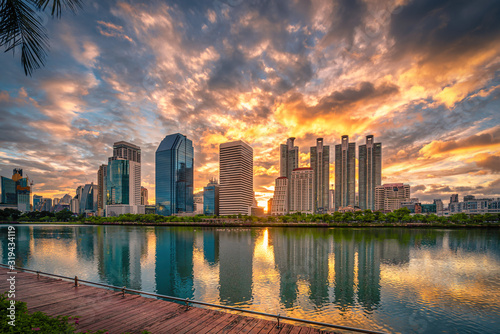 Cityscape image of Benchakitti Park at sunrise in Bangkok, Thailand.