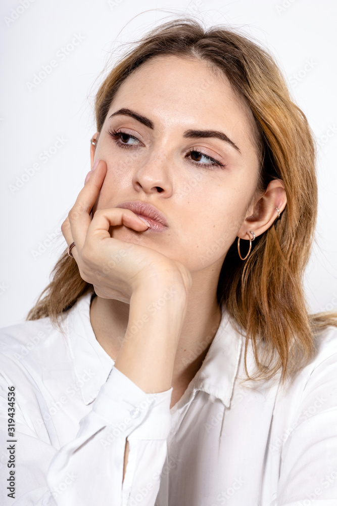 close-up portrait of a young attractive girl with a pensive look and hand in the face on a white background close-up portrait of a young attractive girl with a pensive look and hand in the face on a white background