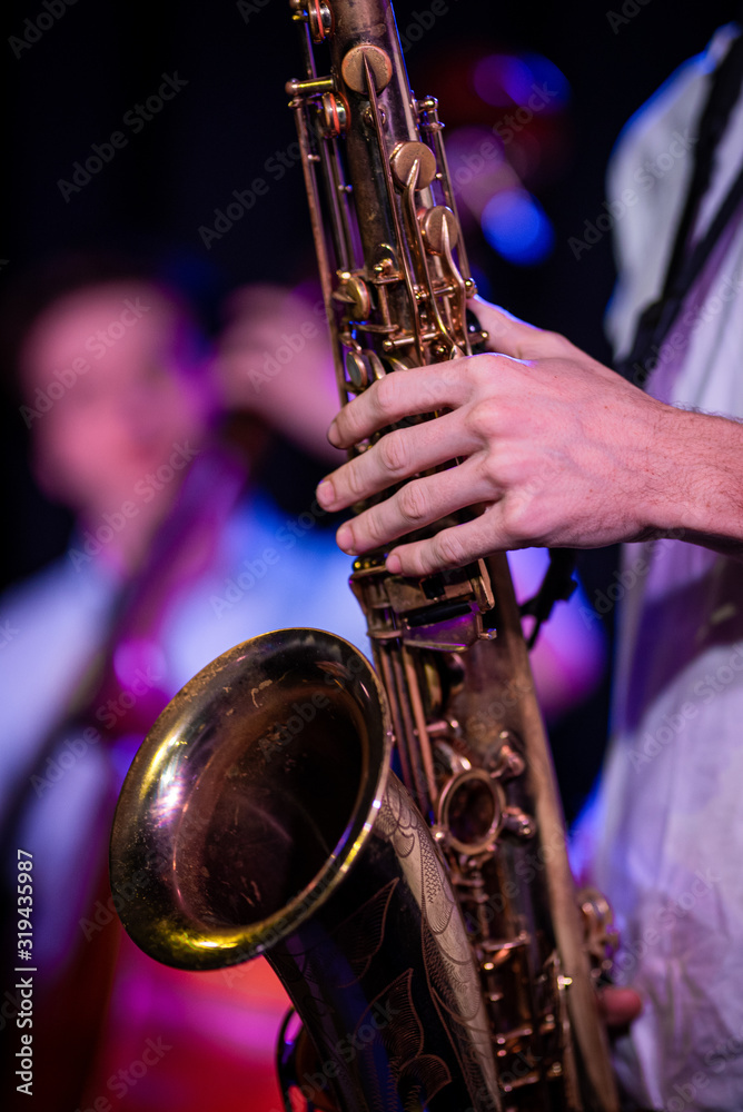 Obraz premium Man holding saxophone with bassist in background