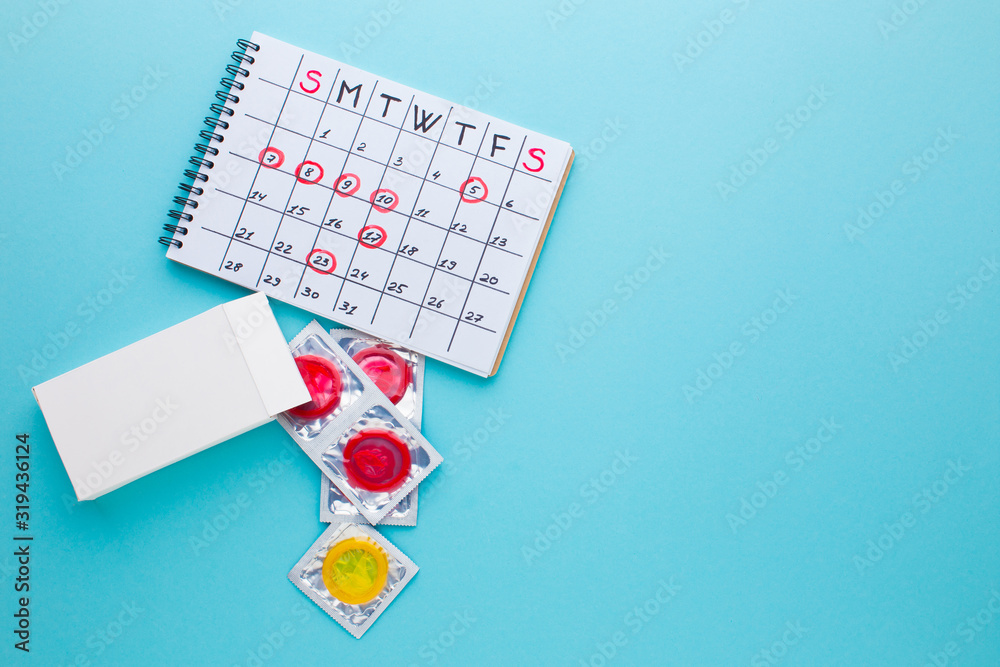 color condom in female hand isolated on a blue background color condom in female hand isolated on a blue background