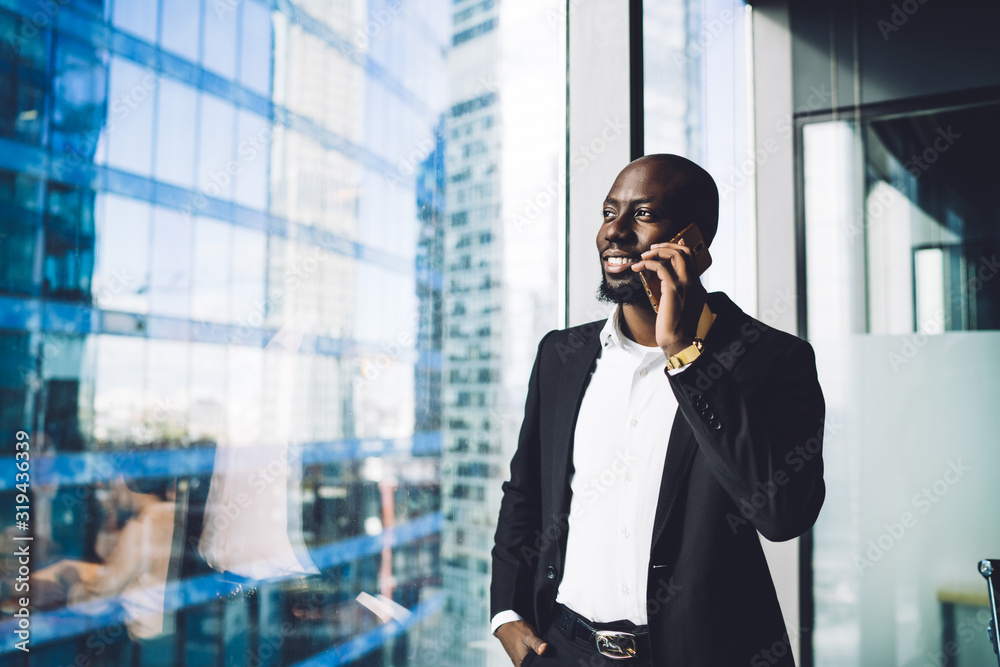 Happy executive man talking on smartphone in office Happy executive man talking on smartphone in office