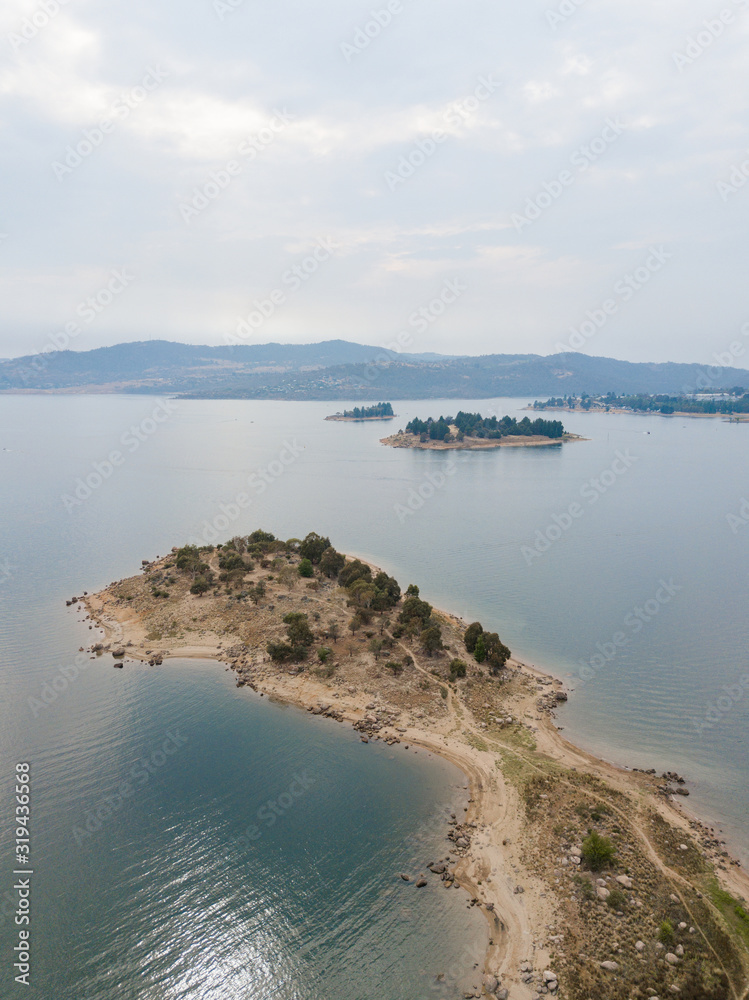 Aerial view of lake coastline under the overcast sky.